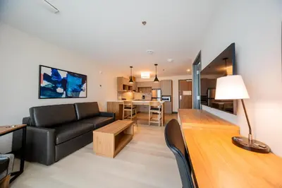 a living room with a black couch and a table at Candlewood Suites Trois-Rivières Ouest by IHG in Trois-Rivières