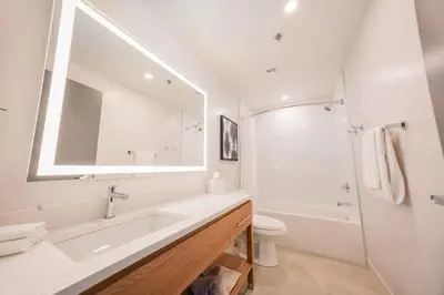 a white bathroom with a sink and a mirror at Candlewood Suites Trois-Rivières Ouest by IHG in Trois-Rivières