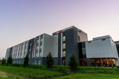 a large glass building with trees in front of it at Candlewood Suites Trois-Rivières Ouest by IHG in Trois-Rivières
