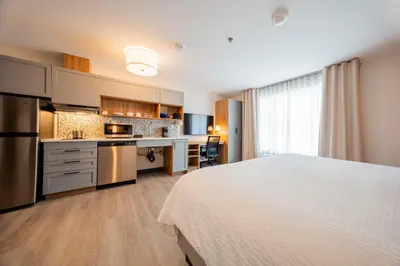 a hotel room with a bed and a kitchen at Candlewood Suites Trois-Rivières Ouest by IHG in Trois-Rivières