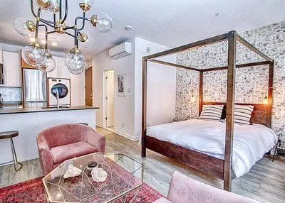 a bedroom with a canopy bed and a living room at The Downtown Zando in Montréal