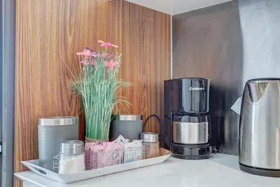 a counter with a coffee maker and flowers on it at The Downtown Zando in Montréal