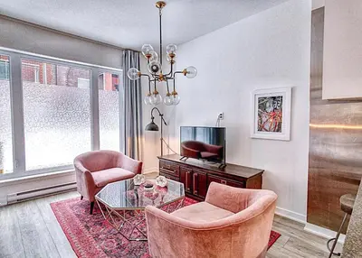 a living room with two chairs and a table at The Downtown Zando in Montréal