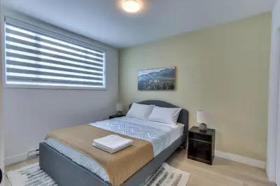a bedroom with a large bed with a window at Le Montreal Adventure! Restful Nights Full Kitchen & Fast Wifi in Montréal