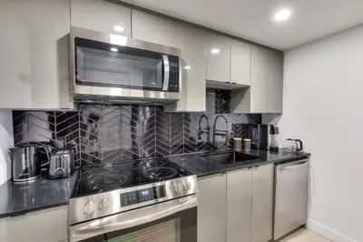 a kitchen with stainless steel appliances and a microwave at Le Montreal Adventure! Restful Nights Full Kitchen & Fast Wifi in Montréal