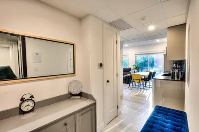 a living room and kitchen with a clock on a counter at Le Montreal Adventure! Restful Nights Full Kitchen & Fast Wifi in Montréal