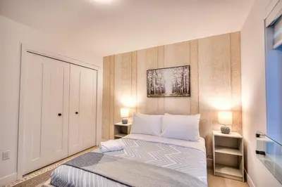 a small bedroom with a bed and two lamps at Le Montreal Adventure! Restful Nights Full Kitchen & Fast Wifi in Montréal