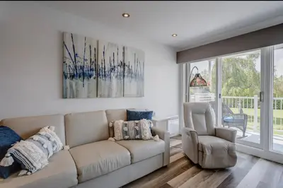 a living room with a couch and a chair at Condo-piscine à 200M du Memphré in Magog-Orford