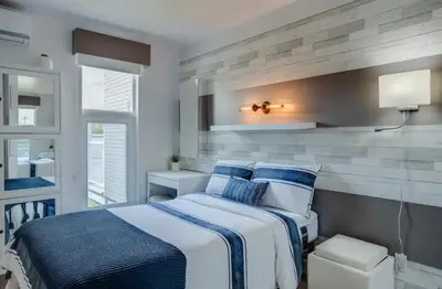 a bedroom with a bed with blue and white sheets at Condo-piscine à 200M du Memphré in Magog-Orford