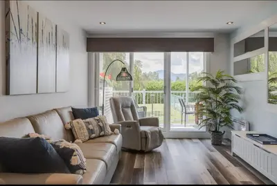 a living room with a couch and a chair at Condo-piscine à 200M du Memphré in Magog-Orford