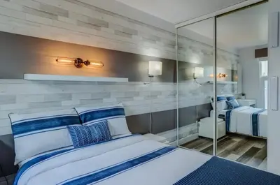 a bedroom with a bed with blue and white pillows at Condo-piscine à 200M du Memphré in Magog-Orford