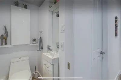 a white bathroom with a toilet and a sink at Condo-piscine à 200M du Memphré in Magog-Orford