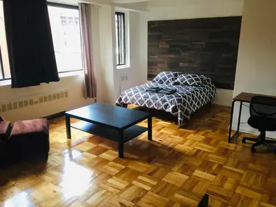 a bedroom with a bed and a table in it at Stylish Montreal Apartment in Montréal