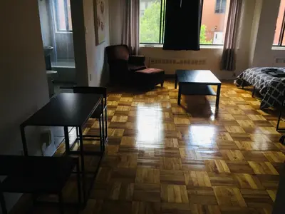 a living room with a wooden floor with a couch and tables at Stylish Montreal Apartment in Montréal