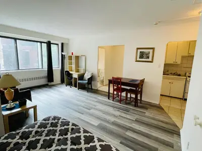 a living room with a table and a kitchen at Stylish Montreal Apartment in Montréal