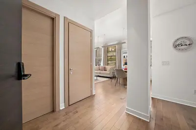 a hallway with a wooden door and a living room at Old Montreal's Luxe Charm in Montréal
