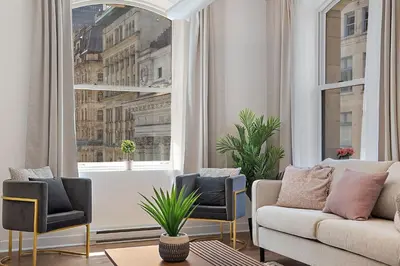 a living room with a couch and chairs and a window at Old Montreal's Luxe Charm in Montréal