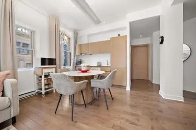 a kitchen and living room with a table and chairs at Old Montreal's Luxe Charm in Montréal