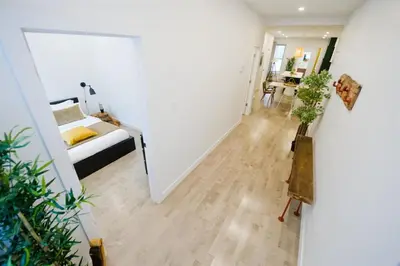 a hallway with a bedroom and a bed and a table at Frontenac residences in Montréal