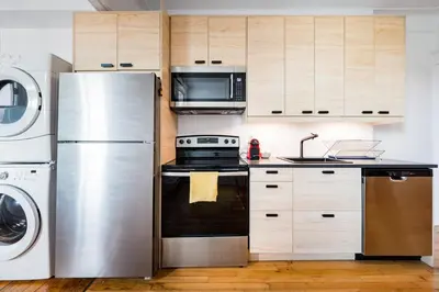 a kitchen with a refrigerator and a washer and dryer at Frontenac residences in Montréal