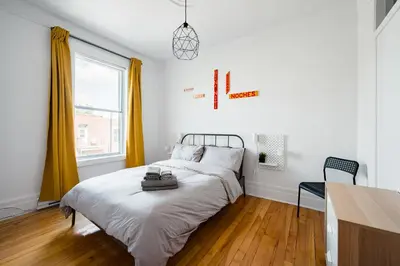 a bedroom with a bed and a desk and a window at Frontenac residences in Montréal