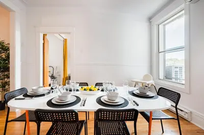 a white dining room with a white table and chairs at Frontenac residences in Montréal