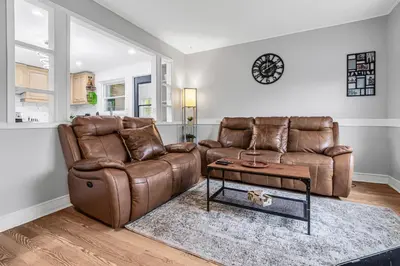 a living room with a brown leather couch and a table at 2 BDR -10 min de la Ronde et Parc Jean Drapeau South Shore Montreal in Longueuil