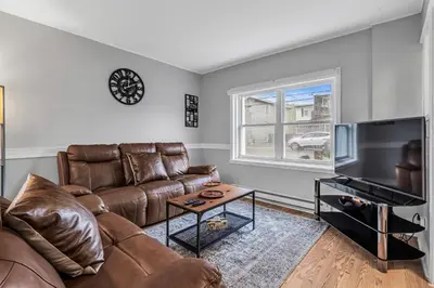 a living room with a couch and a flat screen tv at 2 BDR -10 min de la Ronde et Parc Jean Drapeau South Shore Montreal in Longueuil