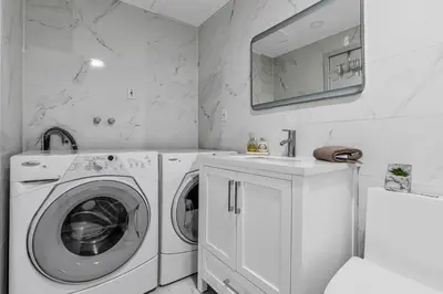 a white laundry room with a washing machine and a sink at 2 BDR -10 min de la Ronde et Parc Jean Drapeau South Shore Montreal in Longueuil