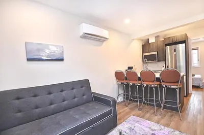 a living room with a couch and a kitchen at Beautiful 2BDR in Heart of Plateau Mont-Royal A in Montréal
