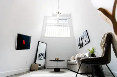 a living room with a couch and a mirror at Le Mile End by M11 - Luxury 1BDR Loft with Sofa Bed in Montréal