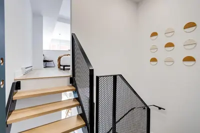 a staircase in a house with a black railing at Le Mile End by M11 - Modern & Stylish 1BDR with Sofa Bed in Montréal