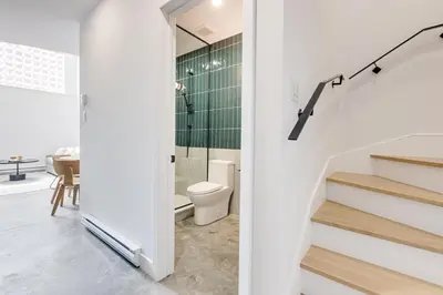 a white bathroom with a toilet and a staircase at Le Mile End by M11 - Modern & Stylish 1BDR with Sofa Bed in Montréal