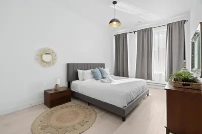 a white bedroom with a bed and a mirror at New Modern 2bdr Apartment in Little Italy in Montréal