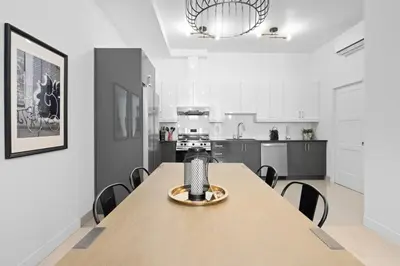 a large kitchen with a wooden table and chairs at New Modern 2bdr Apartment in Little Italy in Montréal