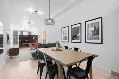 a dining room and living room with a table and chairs at New Modern 2bdr Apartment in Little Italy in Montréal
