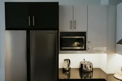 a kitchen with a black refrigerator and a microwave at New Spacious and Cozy 2bdr Apartment in Montréal