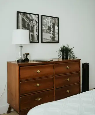 a bedroom with a dresser with a lamp on it at New Spacious and Cozy 2bdr Apartment in Montréal