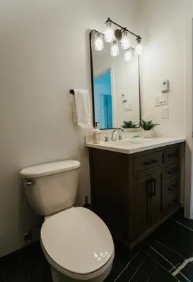 a bathroom with a toilet and a sink with a mirror at Welcoming and Light Filled 2bdr Apartment in Montréal