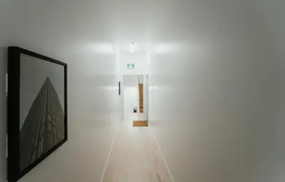 a hallway with white walls and a picture on a wall at Welcoming and Light Filled 2bdr Apartment in Montréal