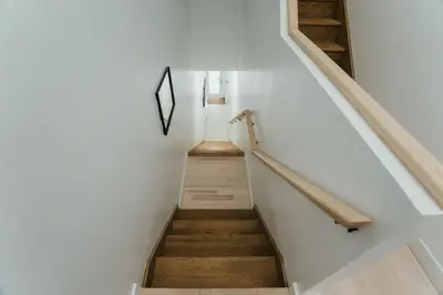 a staircase in a house with white walls and wooden floors at Welcoming and Light Filled 2bdr Apartment in Montréal