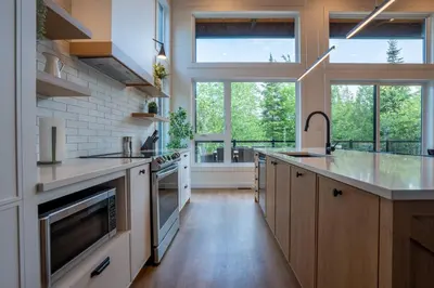 a large kitchen with wooden cabinets and a large window at Évasion Nature Adstock - Sauna, Ski & Spa in Thetford Mines