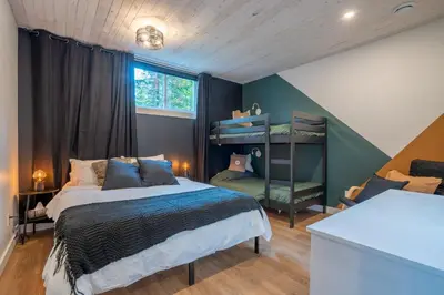 a bedroom with a bed and a bunk bed at Évasion Nature Adstock - Sauna, Ski & Spa in Thetford Mines