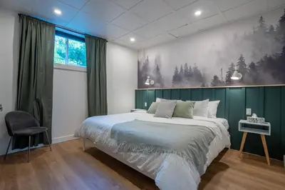 a bedroom with a large bed with a green wall at Évasion Nature Adstock - Sauna, Ski & Spa in Thetford Mines
