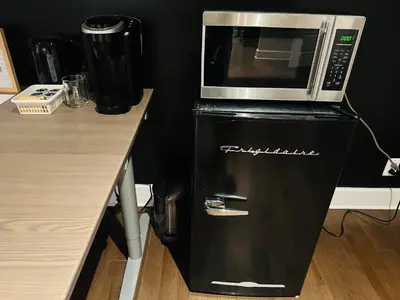 a microwave on top of a refrigerator next to a counter at Urban Retreat - 2 Bedroom, 3 Beds, 6 Guests, Free Parking in Longueuil