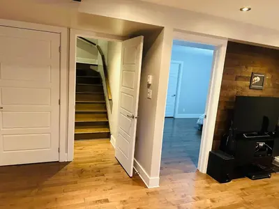a hallway with a staircase and a room with a door at Urban Retreat - 2 Bedroom, 3 Beds, 6 Guests, Free Parking in Longueuil
