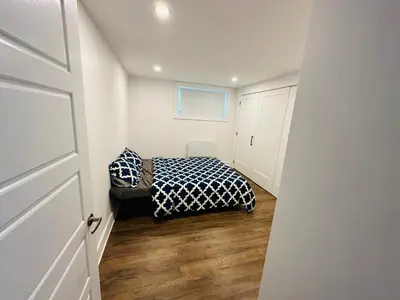 a bedroom with a bed with a black and white blanket at Urban Retreat - 2 Bedroom, 3 Beds, 6 Guests, Free Parking in Longueuil