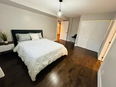 a bedroom with a large white bed and two white doors at Urban Retreat - 2 Bedroom, 3 Beds, 6 Guests, Free Parking in Longueuil