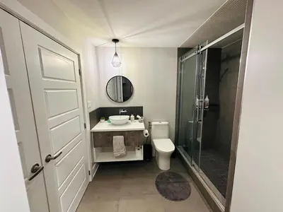 a bathroom with a toilet and a sink and a shower at Urban Retreat - 2 Bedroom, 3 Beds, 6 Guests, Free Parking in Longueuil