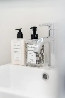 a bathroom sink with two bottles and a faucet at Arcadia Hotel Boutique in Montréal